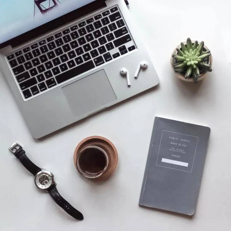 Flat lay bureau: laptop, café, carnet